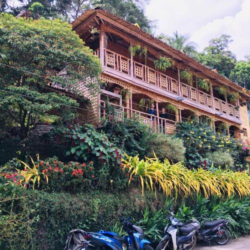 two motorcycles parked in front of a building with flowers at Camiguin Blue Lagoon Cottages in Mahinog