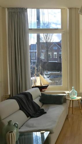 a living room with a large window and a couch at GUESTHOUSE UIT DE KUNST in Leeuwarden