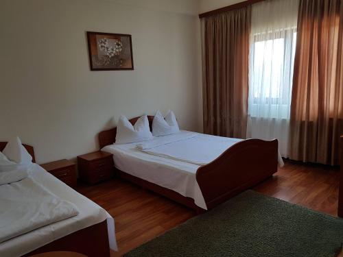 a hotel room with two beds and a window at Vila Orhidee in Eforie Nord