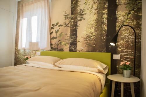 Gardenhouse Sarzana في سارزانا: سرير مع اللوح الأمامي الأخضر في غرفة النوم