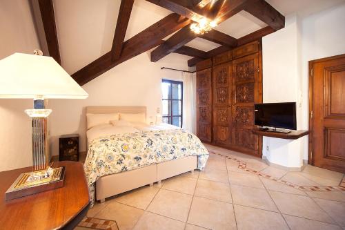 a bedroom with a bed and a table and a tv at Romantik Villa in Andechs