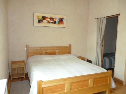 a bedroom with a bed and a picture on the wall at Chambres d'Hôtes Le Bourdieu in Soulignac