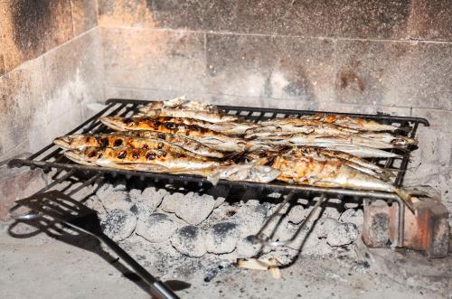 a bunch of fish cooking on a grill at Apartment Villa Lidija in Lovran