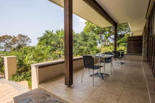 a balcony with a table and chairs on it at One On Hely in Mtunzini