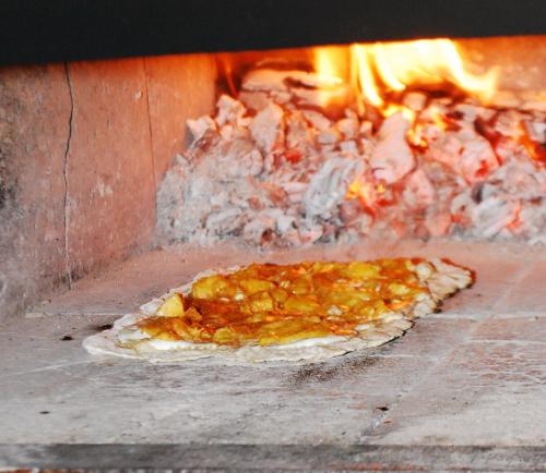 a pizza is being cooked in an oven at Chambres d'Hôtes Le Bourdieu in Soulignac