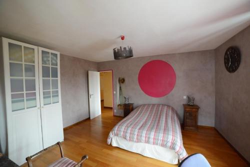 a bedroom with a bed and a red circle on the wall at B&B en Champagne in Cramant