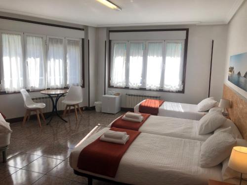 a bedroom with a large bed and a table with chairs at Pensión Amara in Donostia-San Sebastián