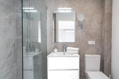 een badkamer met een wastafel, een toilet en een spiegel bij INNER Kompas Palmanova "Adults Only" in Palmanova