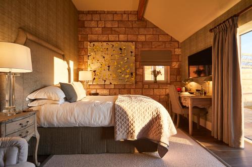 a bedroom with a large bed and a desk at The Duncombe Arms in Ellastone