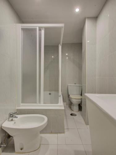 a bathroom with a toilet and a tub and a sink at Emperatriz I in Salamanca