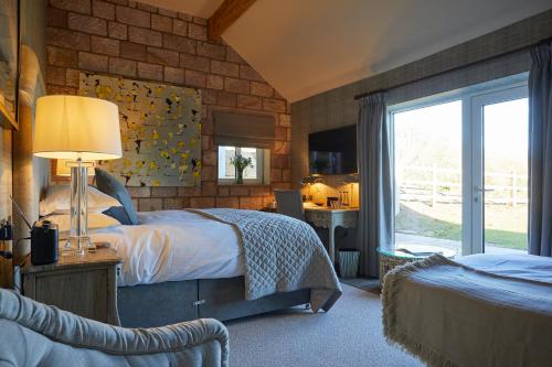 1 dormitorio con 2 camas y ventana en The Duncombe Arms, en Ellastone