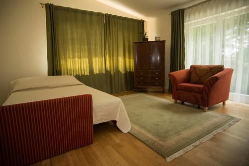 - une chambre avec un lit, une chaise et une fenêtre dans l'établissement Vila Nida, à Palanga