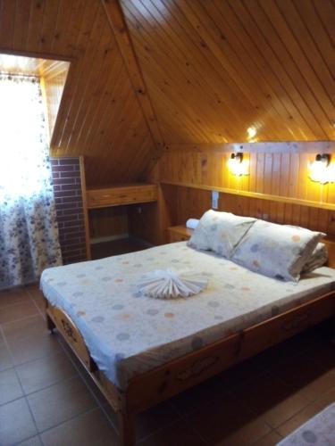 a bed in a room with a wooden ceiling at Doctor's House in Sinemorets