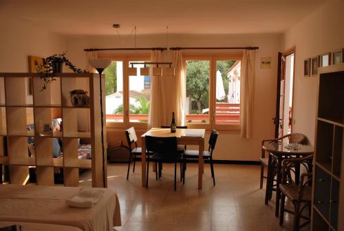 un soggiorno con tavolo, sedie e finestra di Apartaments Margarita Sabina Pinell a Platja  d'Aro