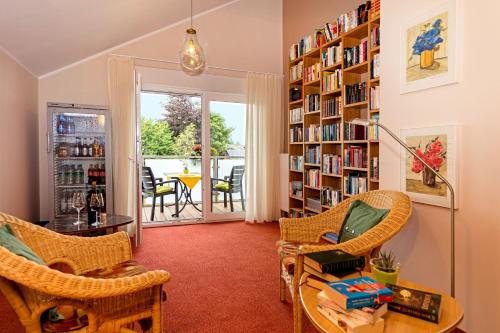 a living room with a book shelf filled with books at Hotel Haus Seeblick in Nideggen