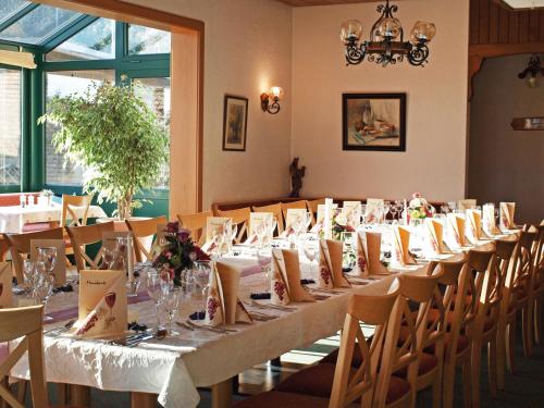 a long table in a room with tables and chairs at Hotel Haus Seeblick in Nideggen