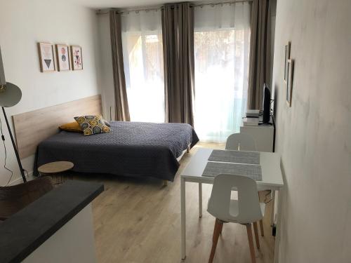 a bedroom with a bed and a table and a window at Aix Homes in Aix-en-Provence