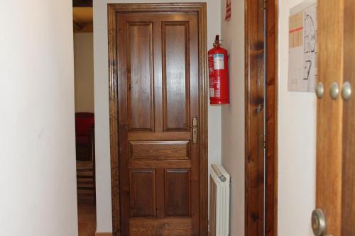 a wooden door in a hallway with a fire extinguisher at Apartamentos Rurales Rosendo: El Azahar in Capileira