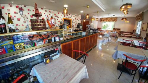 un restaurant avec un bar doté d'une table et de chaises dans l'établissement Casa Tia Teresa, à A Salceda