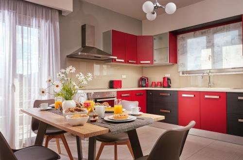 a kitchen with red cabinets and a table with food on it at La Palma Apartments - 2km from Zakynthos Town, by ZanteWize in Zakynthos Town