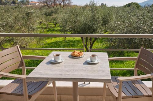 a table with two chairs and a plate of food at La Palma Apartments - 2km from Zakynthos Town, by ZanteWize in Zakynthos Town
