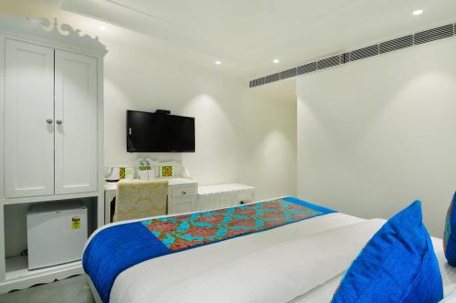 a bedroom with a large bed and a tv at The Pinky Villa - Heritage Boutique Suites- New Delhi in New Delhi