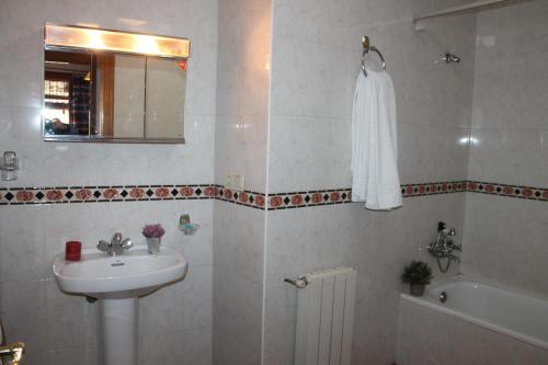 La salle de bains est pourvue d'un lavabo, de toilettes et d'une baignoire. dans l'établissement Apartamentos Rurales Rosendo: El Romero, à Capileira