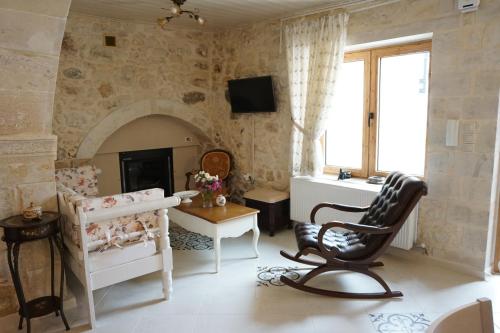 a living room with a chair and a fireplace at Ioanna House in Gonia