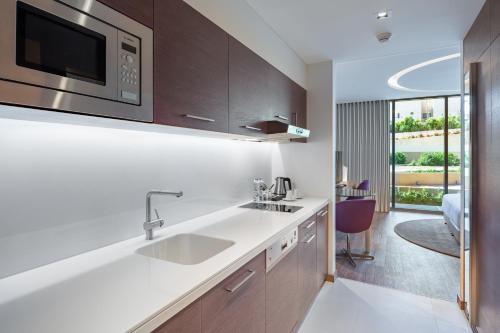 a kitchen with a sink and a microwave at Radisson Blu Hotel & Residence, Riyadh Diplomatic Quarter in Riyadh