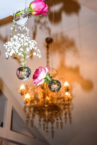 a chandelier with flowers in vases and lights at Hôtel Mercure Paris Suresnes Longchamp in Suresnes