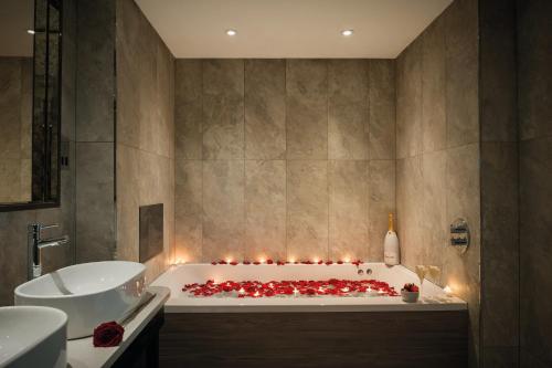 La salle de bains est pourvue d'une baignoire avec des bougies. dans l'établissement Hetland Hall Hotel, à Dumfries