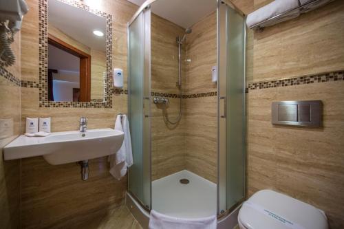 a bathroom with a shower and a sink and a toilet at Hotel Great Polonia Conrad Kraków in Kraków