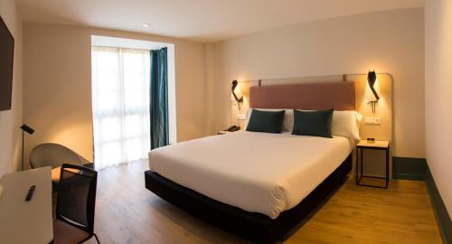 a hotel room with a bed and a window at Hotel Plaza De La Paz in Haro