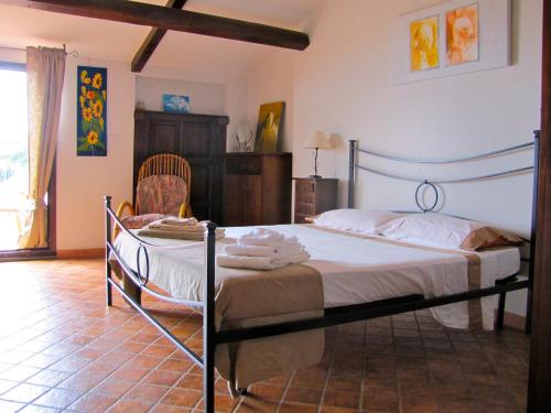a bedroom with a bed and a chair at Slow holidays in Calabria tradizioni eno-gastonomia tra borgo e mare in Badolato