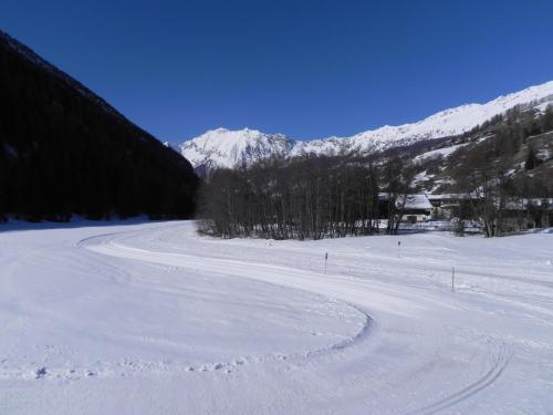 a snow covered road with a mountain in the background at Villa Americana Chambres d'Hotes in Champoluc