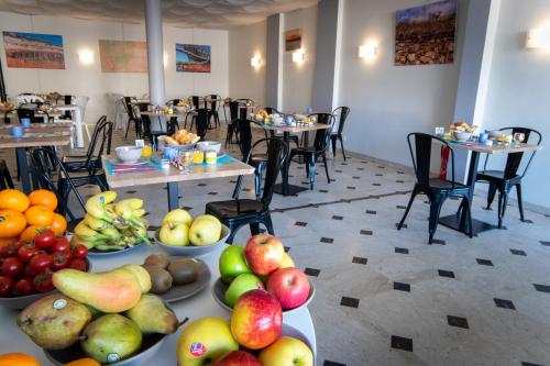 a room with many plates of fruit on tables at Hotel Sables D'or in Sète