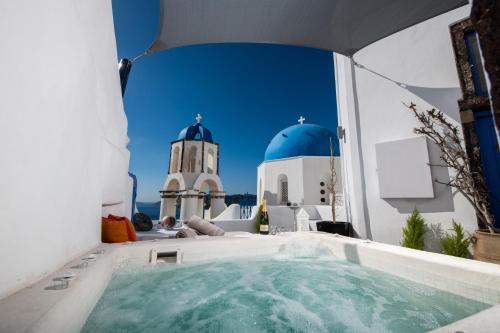 bañera de hidromasaje en el balcón de una casa con faro en Santo Blue Horizon, en Oia