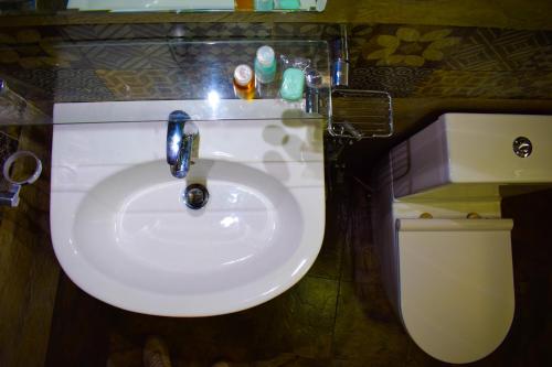 a bathroom with a white sink and a toilet at Blue Moon Hotel in Nuwara Eliya