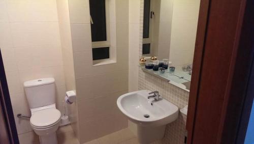 a white bathroom with a toilet and a sink at luxuries, central Hostel ,sleep 2 in Il-Gżira