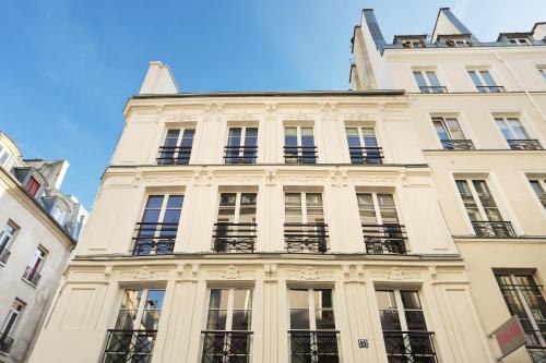 un grand bâtiment blanc avec des fenêtres et une tour dans l'établissement Résidence Grands Boulevards by Studio prestige, à Paris