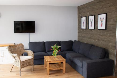 a living room with a blue couch and a table at Welcome in - Wohnung mit Dachterrasse direkt an der Piste in Winterberg