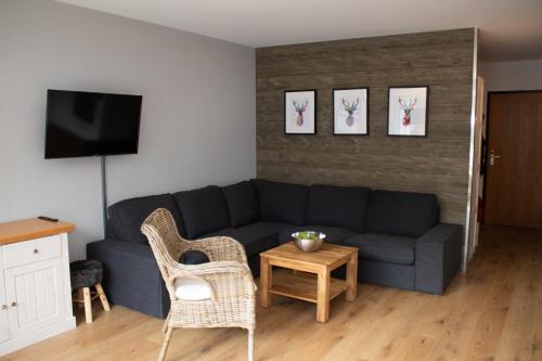 a living room with a couch and a table and chairs at Welcome in - Wohnung mit Dachterrasse direkt an der Piste in Winterberg