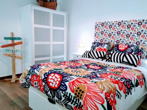 a bedroom with a bed with a colorful comforter at Loft Azahar junto a Puente Romano in Córdoba