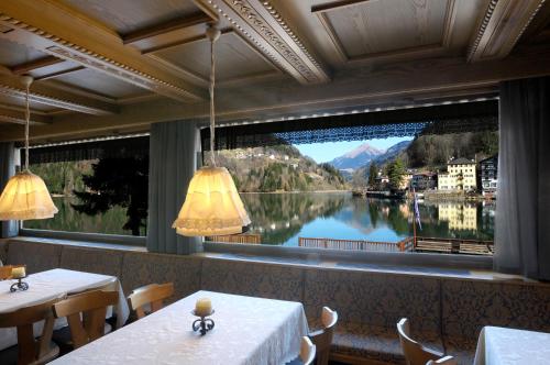 a restaurant with a large window with a view of a lake at Sporthotel Europa Sul Lago in Alleghe