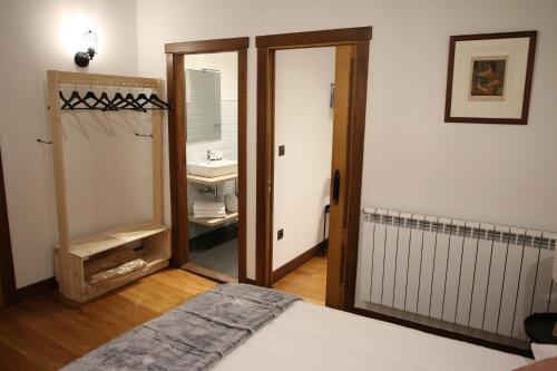 een slaapkamer met een bed en een badkamer met een wastafel bij Casa Rural Iruso in Leitza