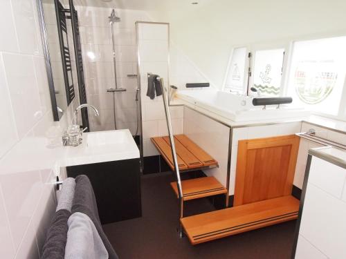 uma casa de banho com um lavatório e um chuveiro em B&B Pension "Op'e Koai" em Jirnsum