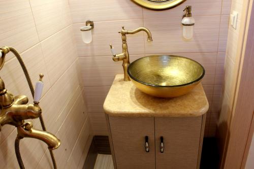 a bathroom with a gold bowl sink on a counter at Ioanna House in Gonia