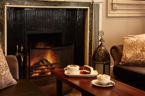 a fire place in a living room with a fireplace at Hetland Hall Hotel in Dumfries