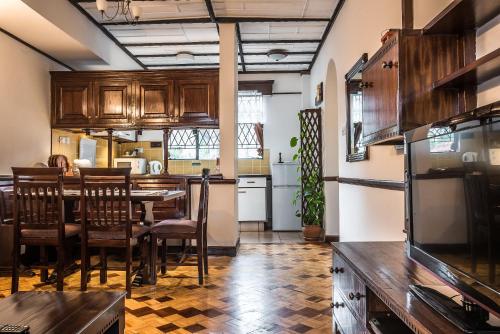 Una cocina y un comedor con mesa y sillas. en The Grand Gables, en Nairobi