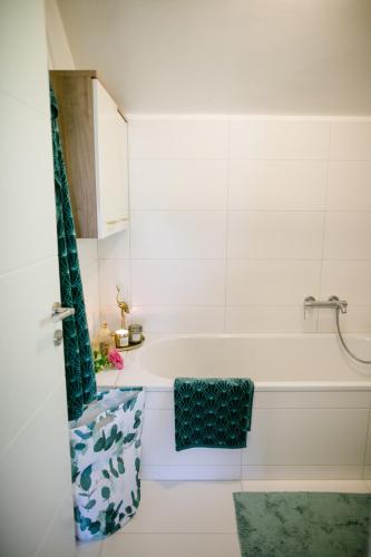 a bathroom with a tub and a green shower curtain at Hallstatt Lake View House in Hallstatt